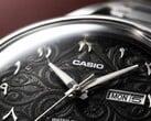 Grande plano do mostrador preto do Casio MTP-E735AR, com um intrincado padrão de arabescos, algarismos árabes orientais em relevo, ponteiros polidos em tom prateado e uma janela de dia e data às 3 horas.