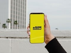 Uma mão segurando um smartphone com a palavra “eSIM” em letras grandes em uma tela amarela.