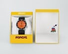 Relógio automático Seiko 5 Sports x Popeye HDB013, com mostrador laranja, ao lado de sua caixa de apresentação amarela de edição limitada.