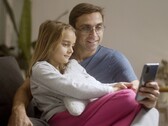 Um pai e sua filha olhando juntos para um smartphone