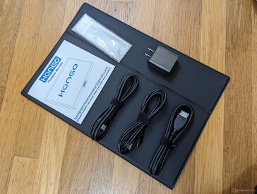 Os acessórios incluem um cabo USB-C para USB-C, um cabo USB-A para USB-C para alimentação, um cabo HDMI, um adaptador CA USB-A de 15 W, um pano de limpeza de veludo, um manual e uma capa protetora de couro sintético