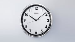 Relógio de parede de quartzo retro Seiko KX701S com moldura prateada e mostrador em preto e branco contrastantes.