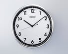 Relógio de parede de quartzo retro Seiko KX701S com moldura prateada e mostrador em preto e branco contrastantes.