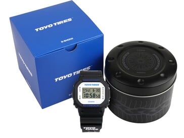 Relógio Casio G-Shock DW5600TT25-1 exibido com sua caixa azul da Toyo Tires e lata de metal personalizada.