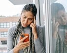 Uma mulher olha para o smartphone com uma expressão séria