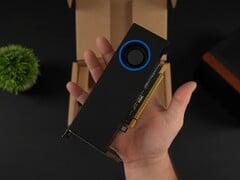 Uma pessoa segurando a GPU para estação de trabalho de baixo perfil Intel Arc Pro B50 com um cooler do tipo soprador, mostrada contra a caixa da embalagem. (Fonte da imagem: ETA Prime via YouTube)
