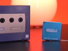 Uma captura de tela mostrando o Nintendo Gamecube ao lado do minúsculo Nintendo Kawaii Wii do tamanho de um chaveiro
