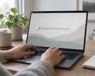 Mãos no teclado de um laptop, um controle deslizante na extremidade esquerda da tela