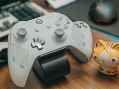Controle de Xbox branco apoiado em uma mesa de madeira ao lado de uma pequena estatueta de gato (Fonte da imagem: FOX ^.ᆽ.^= ∫ via Pexels)