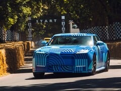O Jaguar Type 01 EV, com a pintura “Blue Exuberant Modernism Camouflage”, passando em alta velocidade pela grade de largada na Goodwood Hill Climb
