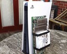 Um console PlayStation 5 colocado ao lado de uma placa AMD BC250 personalizada montada com um dissipador de calor e um ventilador de resfriamento. (Fonte da imagem: Budget-Builds Official via YouTube)