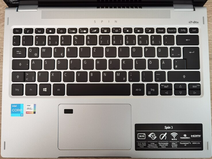 Um teclado antiderrapante com iluminação brilhante que é propenso a impressões digitais.